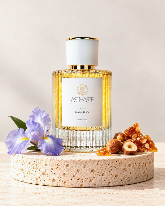 Parfum Éclate de Vie Astharte 100 ml pe piatră de travertin, cu iris, alune caramelizate și praline